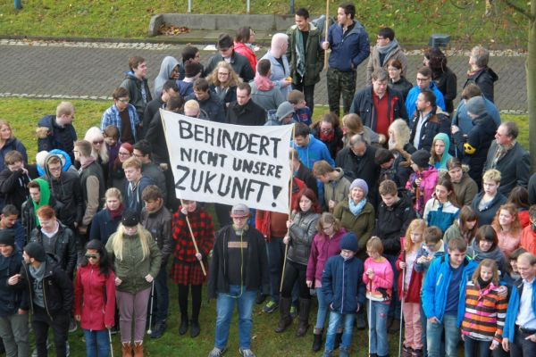 Protest mit Plakat: Behindert nicht unsere Zukunft